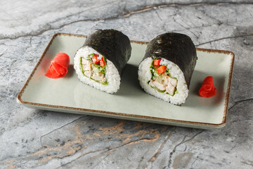 American Japanese Fusion Burrito Sushi with Grilled Chicken, Rice, Garlic, Cream Cheese, Cucumber, Bell Pepper, Nori and Lettuce Close-up in Plate on Table. Horizontal