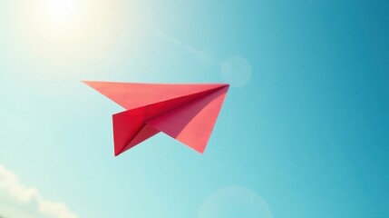 A vibrant red paper airplane gracefully soars through a clear azure sky, bathed in the warm glow of sunlight, symbolizing dreams taking flight and aspirations reaching for the heavens.