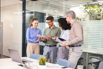 Naklejka premium Group of young modern people in formalwear using modern technologies while working in the creative office