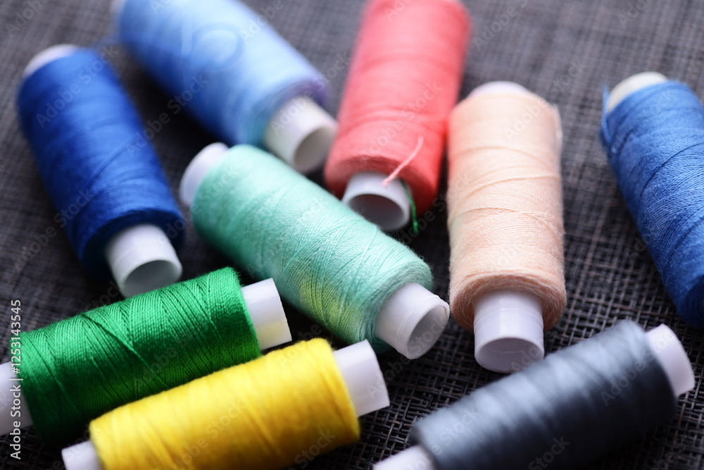 Poster a collection of thread spools arranged neatly on a table, suitable for crafting, sewing, or diy proj