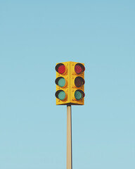 yellow traffic light stands tall against clear blue sky, signaling caution and safety