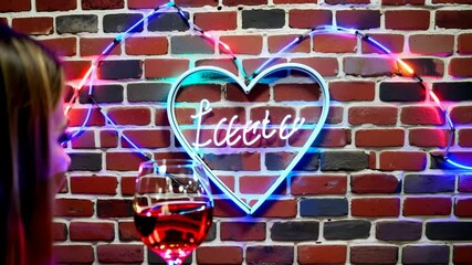 date night neon lights text and wine glass with heart frame on brick wall animation, valentine love - Powered by Adobe