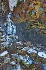 Russia. South of Western Siberia. One of the most beautiful waterfalls of the Altai Mountains on the Karasu River near the village of Chibit on the Chui tract, chained with ice of autumn frosts.