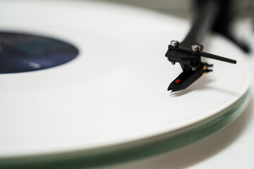 White vinyl player with speaker system and rock record in white shade. Musician places a white...