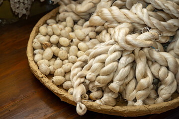 A basket filled with delicate silk threads intertwined with silkworm cocoons