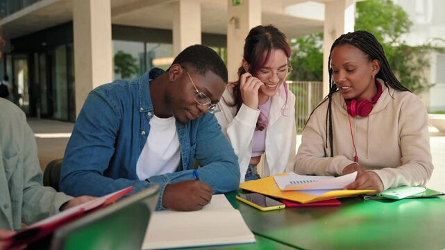 African American and Hispanic students tutoring for exams and studying together at the Uni library