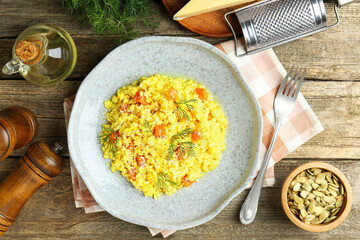 Delicious pumpkin risotto served on wooden table, flat lay