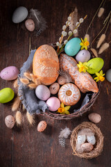 Traditional Easter basket with flowers, painted eggs and bread.