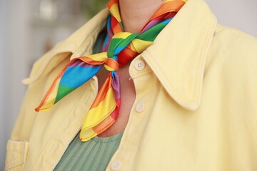Woman wearing neckerchief in LGBT colors indoors, closeup