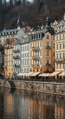 Obraz premium ** Karlovy Vary Charm: Riverside Buildings & Reflections in Czech Republic