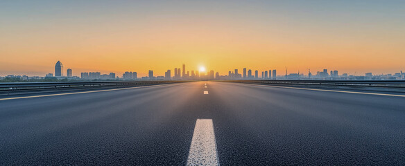 Obraz premium Sunrise over an empty highway leading to city skyline