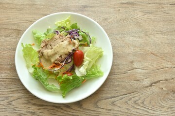 mashed tuna with vegetable salad dressing Japanese roasted sesame cream sauce on plate