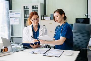 Obraz premium Doctors and nurses collaborating in a modern medical office, showcasing teamwork and patient care.