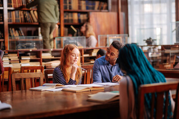 Students talking about classes in library.