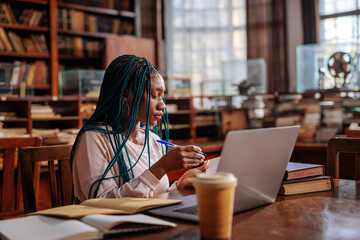 Student doing school assignment in library.