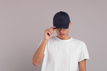 Man in stylish baseball cap on grey background. Mockup for design