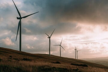 Obraz premium Wind turbines on a hill at sunset. Possible use stock photo