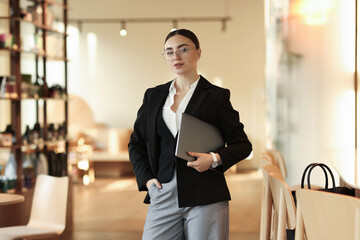 Fototapeta premium Woman in stylish formal suit with laptop indoors