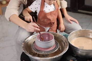 Hobby and craft. Daughter with her mother making pottery indoors, closeup