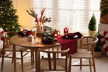 Christmas table setting with stylish dishware and festive decor indoors