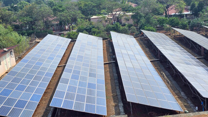 Side angle shot of  Solar panel system near small village in Maharashtra, India