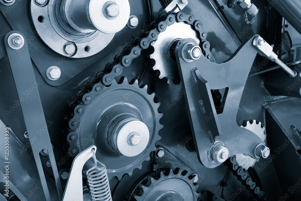 Poster A close up of a chain drive mechanism. The chain drive is made up of many small gears and is very intricate industrial concept background