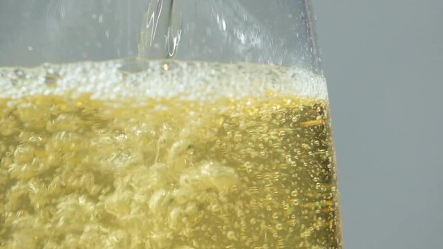 Apple cider vinegar is poured, slow motion macro, lots of bubbles in liquid