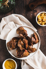 Homemade stewed chicken liver on a plate on the table top and vertical view