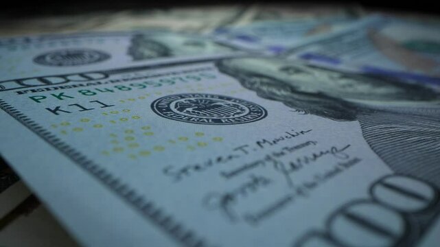Concept of finance and money payment. Extreme close-up one hundred dollar bills. Dolly shot. Fiat money. Camera moving. 4K, UHD