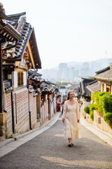 Obraz premium Woman walking through Bukchon Hanok Village