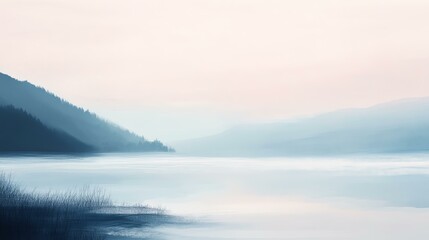 Fototapeta premium Calm lake surrounded by misty mountains.