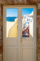 Rue traditionnelle de Oia à Santorin, à travers une porte virée,  île des Cyclades, Grèce.