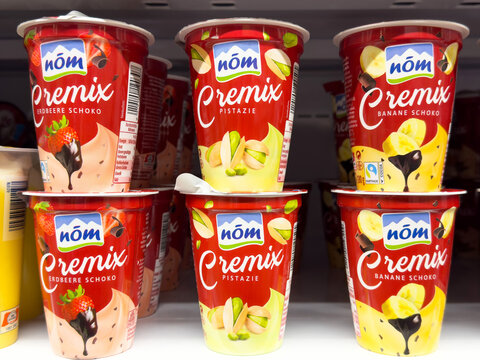Assorted n&ouml;m cremix yogurt cups on shelf with various flavors