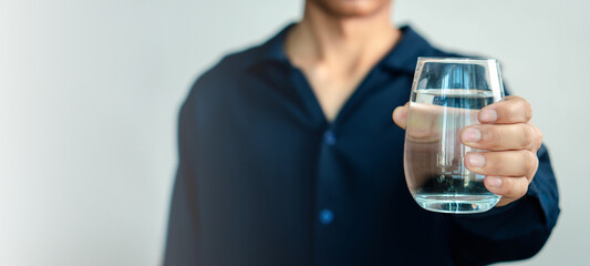 Man Drinking Water, man holding glass drinks still water preventing dehydration, helps maintain normal bowel function and balance of body, skin and health care, healthy lifestyle concept