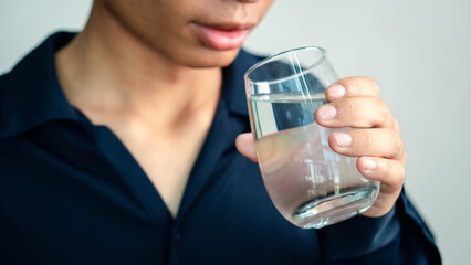 Man Drinking Water, man holding glass drinks still water preventing dehydration, helps maintain normal bowel function and balance of body, skin and health care, healthy lifestyle concept