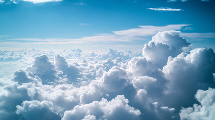 A breathtaking view of fluffy white clouds against a vibrant blue sky, creating a serene and expansive atmosphere, reminiscent of being high above the earth.