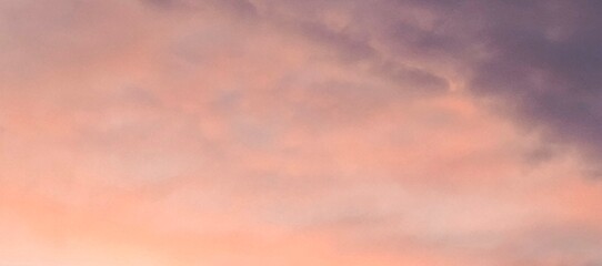 Pink and purple hues in evening sky.A dreamy sky with a blend of pink and purple hues at sunset,...