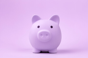 Piggy bank isolated on purple background. Concept of saving money and investing for the future.