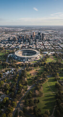 Fototapeta premium Melbourne Marvel: Aerial View of the MCG, City Skyline & Lush Parks - Australia's Sporting Heart & Urban Beauty!