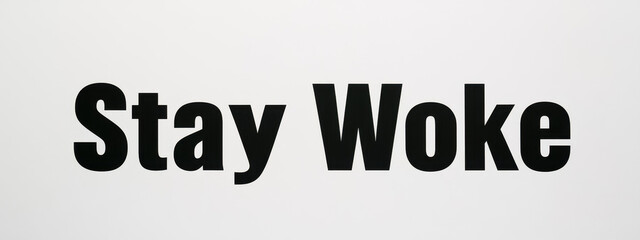 Fototapeta premium Black text 'Stay Woke' on a plain white background, emphasizing awareness and social consciousness.