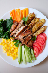 Healthy salad filled with roasted chicken and colorful vegetables.