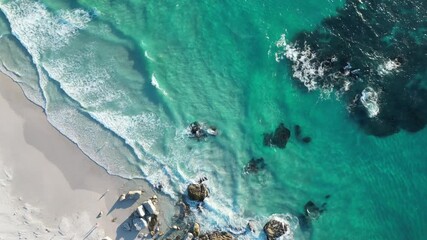 Aerial Drone footage of waves crashing on the beach at sunset