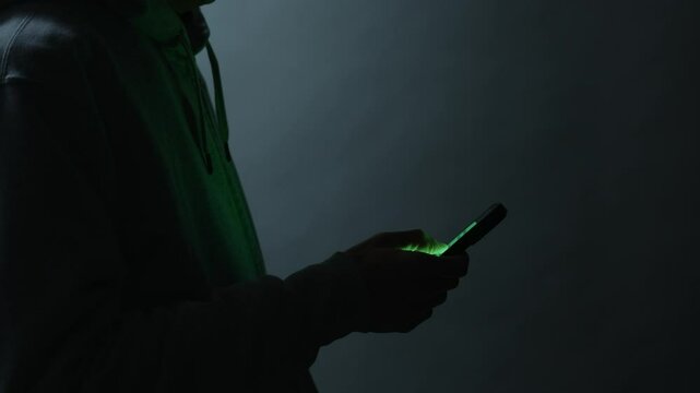 闇バイト、振り込め詐欺のなどの犯罪をイメージするスマートフォンを操作する男性の手元
