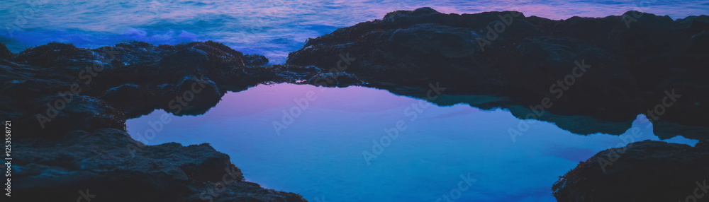 Poster small tidal pool with glowing rocks under a bright sky and serene waves