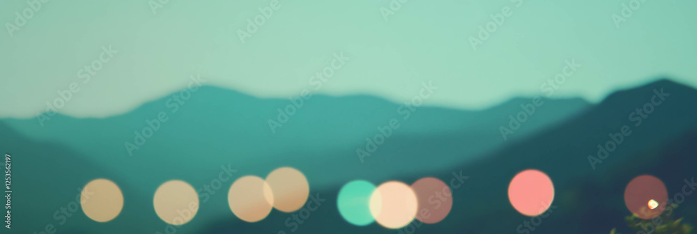 Aufkleber Blurred mountain range with distant bokeh lights creating a vibrant backdrop