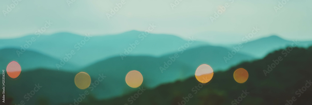 Poster blurred mountain landscape with colorful bokeh lights and bright background for depth