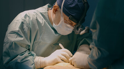 Two doctors operating patient in clinic hospital surgeon man medic physician perform surgical...