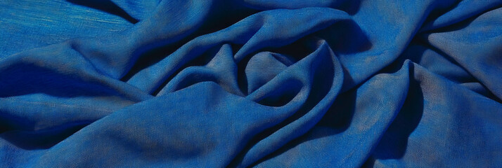 Deep indigo cotton fabric with chambray weave on bright background showcasing texture