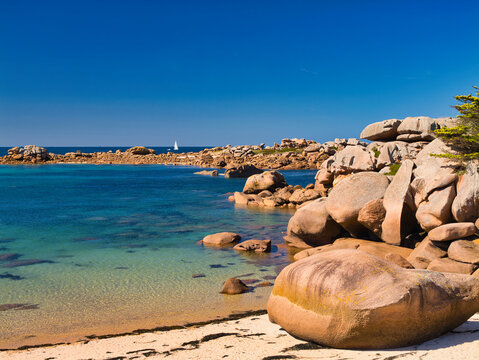 Rock formations on the famous Pink Granite Coast near Ploumanac'h in Perros-Guirec, Lannion, Brittany in Northern France. Taken on a sunny day in summer, with a blue sky and light cloud.