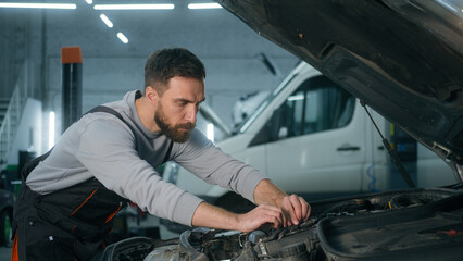 Caucasian man mechanic technician industrial worker repairman engineer in uniform male guy car service manager repair car electric automobile wreck engine problem trouble diagnostics in garage station